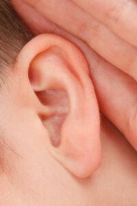Human ear with a hand at the side