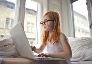 A young girl studying on the computer.