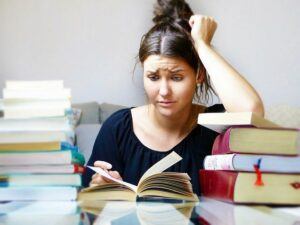 Frustrated girl studying a book.