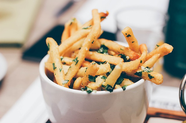 A bowl of French fries with spices.