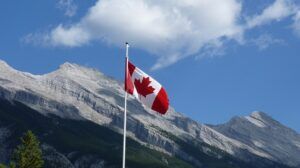 Canadian flag with a mountain in the background.
