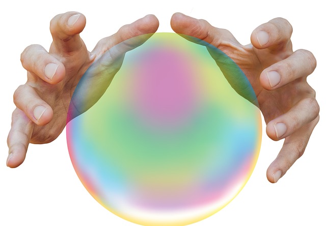 Two hands touching a crystal ball.