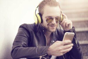 Young man listening to music on his yellow headphones.