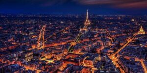 Paris lit at night with the Eiffel Tower in the distance.